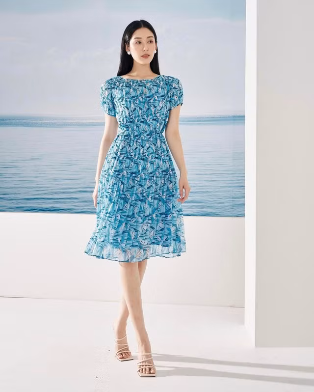 Thiết kế đầm họa tiết hoa lá sử dụng chất liệu tơ lụa mỏng nhẹ, mềm mại mang đến cảm giác thoải mái và dễ chịu cho người mặc. Với sắc xanh dương tươi trẻ làm chủ đạo, mẫu váy là lựa chọn hoàn hảo cho những ngày hè nóng bức.