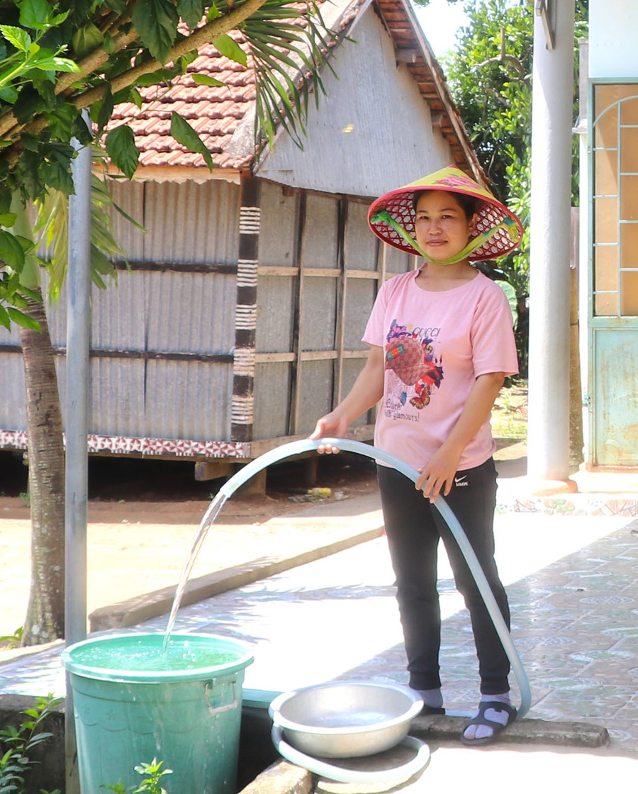 Chị Đinh Thị Bắc (làng Lợk, xã Nghĩa An, huyện Kbang) phấn khởi khi được sử dụng nguồn nước hợp vệ sinh. Ảnh: N.M