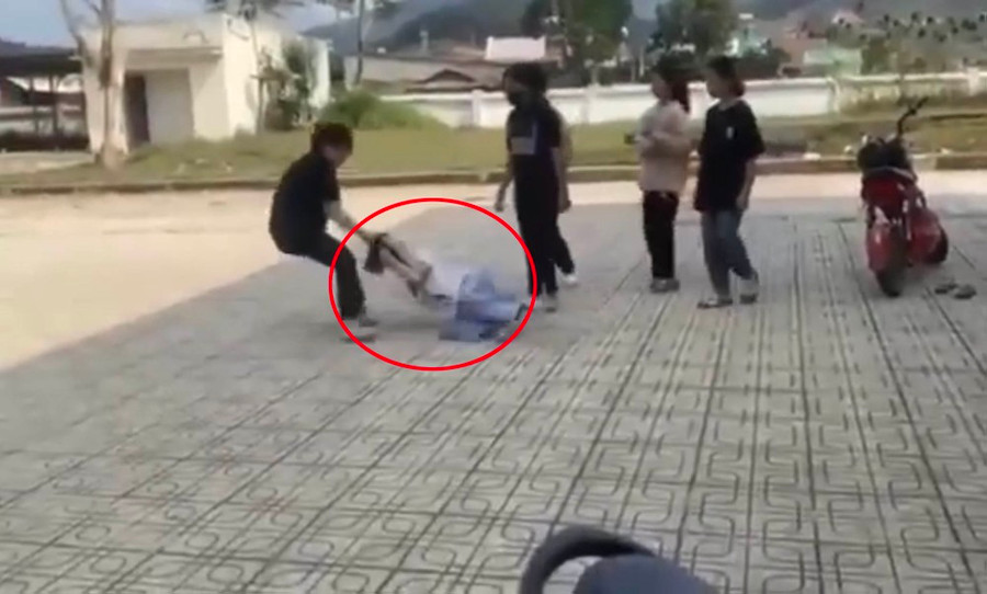 Nữ sinh bị túm tóc kéo lê trên sân gạch. Ảnh chụp lại từ video