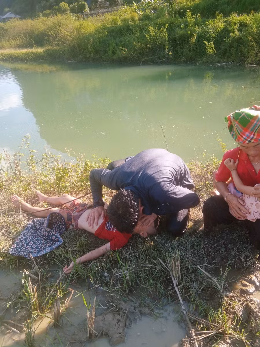 Anh Lò Văn Thanh sơ cứu cho cháu bé bị ngạt nước, chiều 26-7. Ảnh: DƯƠNG ĐINH