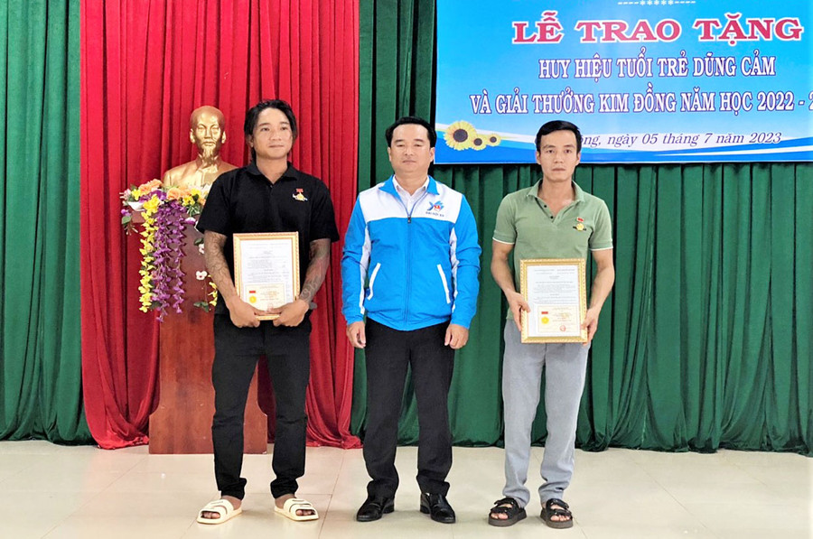Anh Đỗ Duy Nam-Phó Bí thư Tỉnh Đoàn trao tặng huy hiệu &quot;Tuổi trẻ dũng cảm&quot; cho anh Nguyễn Văn Bá (bìa trái) và anh Đỗ Đình Huấn. Ảnh: Hà Đức Thành