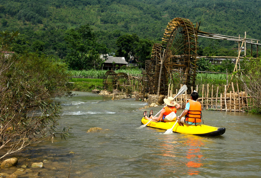 Khách du lịch chèo kayak trên suối Chàm, phía xa là những cọn nước của người Thái. Ảnh: Pù Luông Retreat Khách du lịch chèo kayak trên suối Chàm, phía xa là những cọn nước của người Thái. Ảnh: Pù Luông Retreat