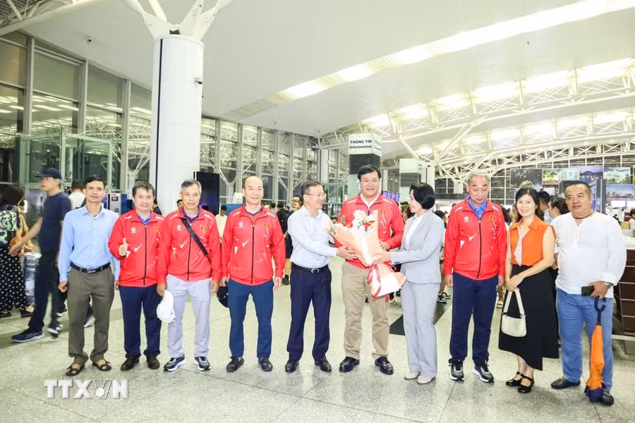 Ông Nguyễn Hồng Minh, Phó Cục trưởng Cục Thể dục Thể thao và bà Lê Hoàng Yến, Phó Cục trưởng Cục Thể dục Thể thao, tặng hoa cho ông Đặng Hà Việt. (Ảnh: Hoàng Linh/TTXVN)