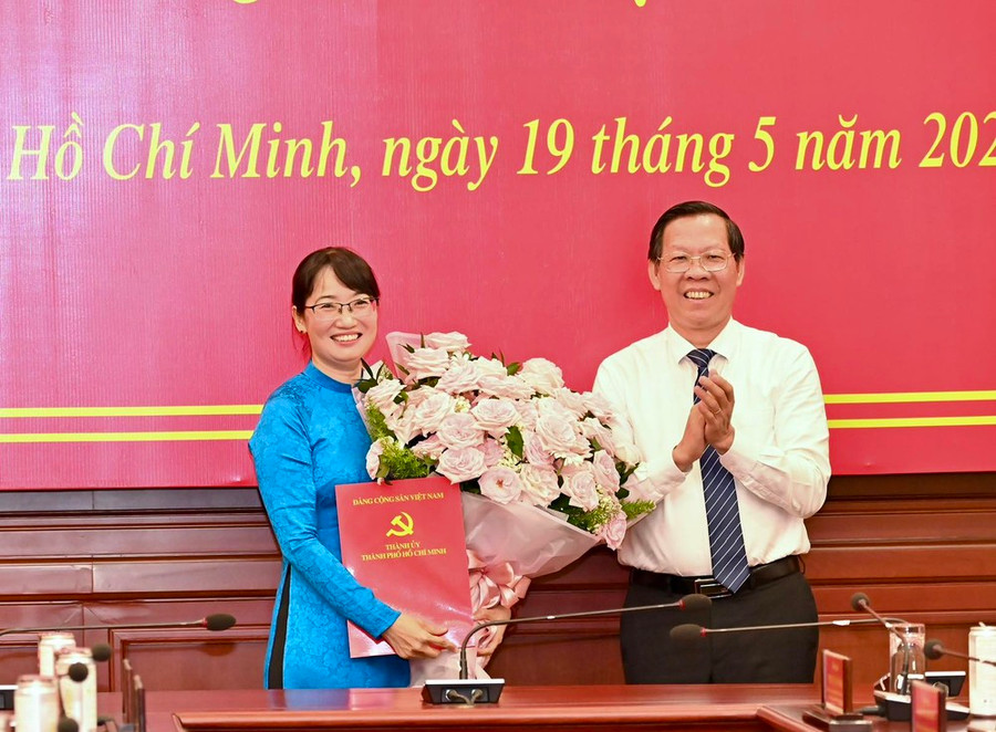 Chủ tịch UBND TPHCM Phan Văn Mãi chúc mừng đồng chí Trần Thị Diệu Thúy. Ảnh: VIỆT DŨNG