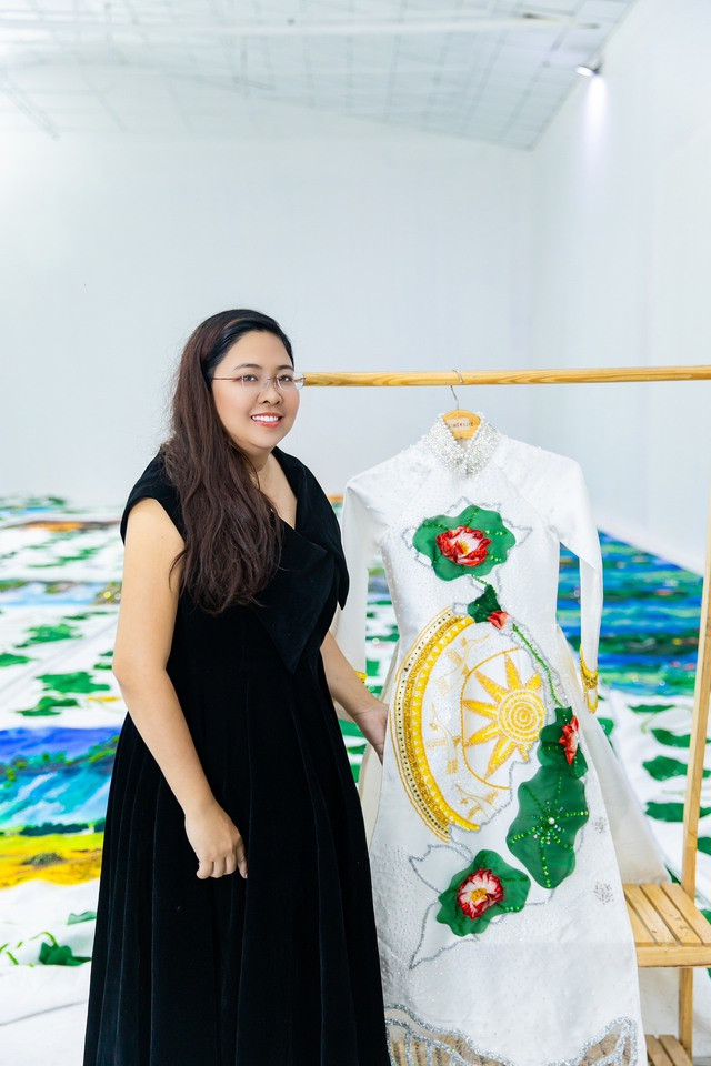 Nhà thiết kế Phương Hồ chụp ảnh cùng chiếc áo dài Non sông gấm vóc. Ảnh: NVCC