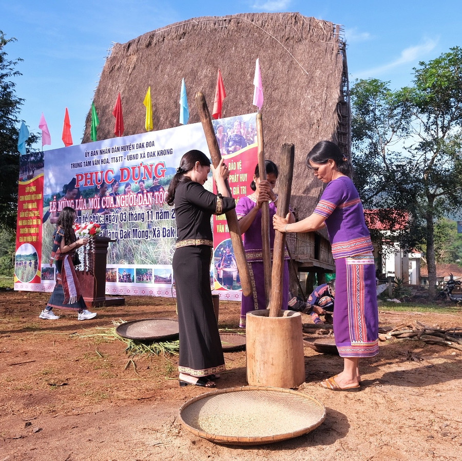 Phụ nữ giã gạo nấu cơm mới dâng lên các vị thần linh. Ảnh: Hoàng Ngọc