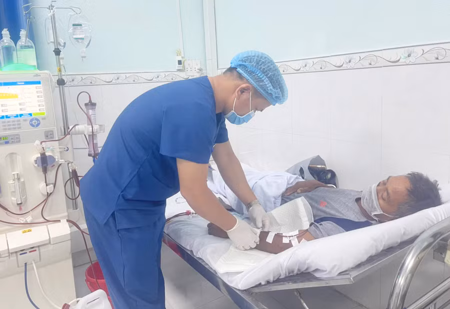 Điều dưỡng viên Ksor Thuyên chăm sóc bệnh nhân Ksor Bren (thôn Sô Ma Lơng, xã Chrôh Pơnan, huyện Phú Thiện). Ảnh: Vũ Chi