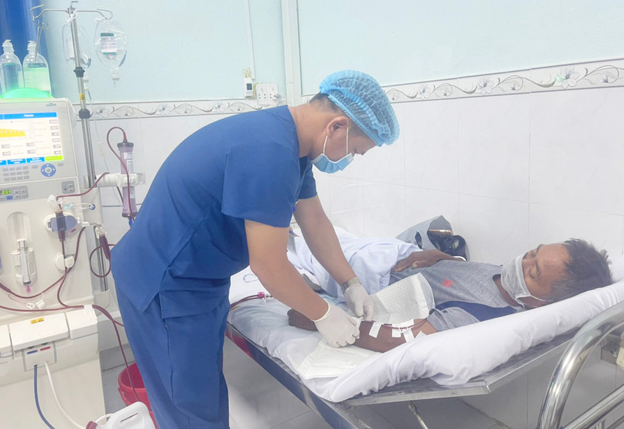 Điều dưỡng viên Ksor Thuyên chăm sóc bệnh nhân Ksor Bren (thôn Sô Ma Lơng, xã Chrôh Pơnan, huyện Phú Thiện). Ảnh: Vũ Chi