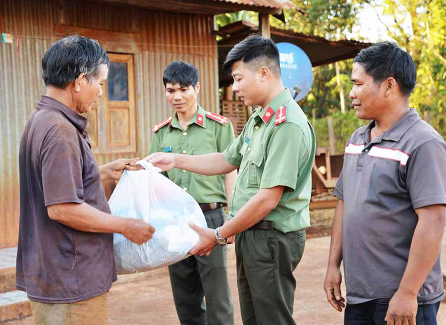 Cán bộ Phòng An ninh đối nội (Công an tỉnh) tặng quà cho hộ DTTS có hoàn cảnh khó khăn. Ảnh: Hữu Trường