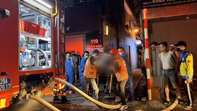 Lực lượng chức năng đưa nạn nhân vụ cháy nhà trọ ra ngoài hiện trường. Ảnh: Khắc Hiếu