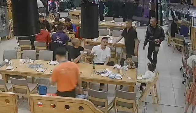 Đà Lạt: Một người đàn ông bất ngờ bị đánh trong nhà hàng trước mặt vợ con - Ảnh 1. Anh T. (áo trắng) ngồi với các con trước khi bị đánh. CẮT TƯ CAMERA