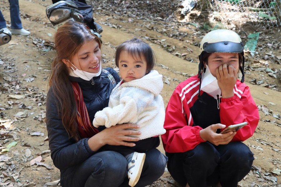 Người mẹ trẻ đưa con lên núi chăm sóc sâm. Ảnh: HỮU PHÚC