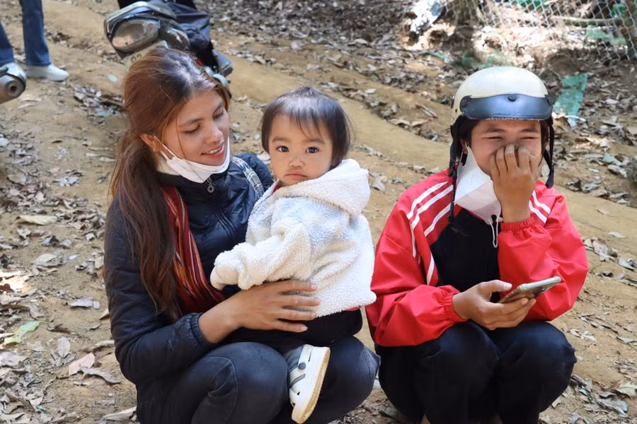 Người mẹ trẻ đưa con lên núi chăm sóc sâm. Ảnh: HỮU PHÚC