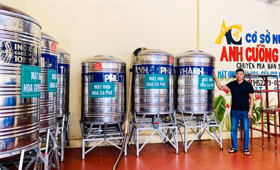 Anh Trần Văn Cường bên các bồn chứa mật ong tại cơ sở chế biến của gia đình. Ảnh: N.H Anh Trần Văn Cường bên các bồn chứa mật ong tại cơ sở chế biến của gia đình. Ảnh: N.H