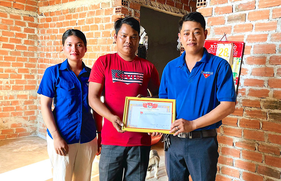 Bí thư Đoàn xã Ia Lâu Nguyễn Thế Sơn Kiên (bìa phải) tặng giấy khen “Gương người tốt, việc tốt” cho anh Kpă Ayut. Ảnh: H.T