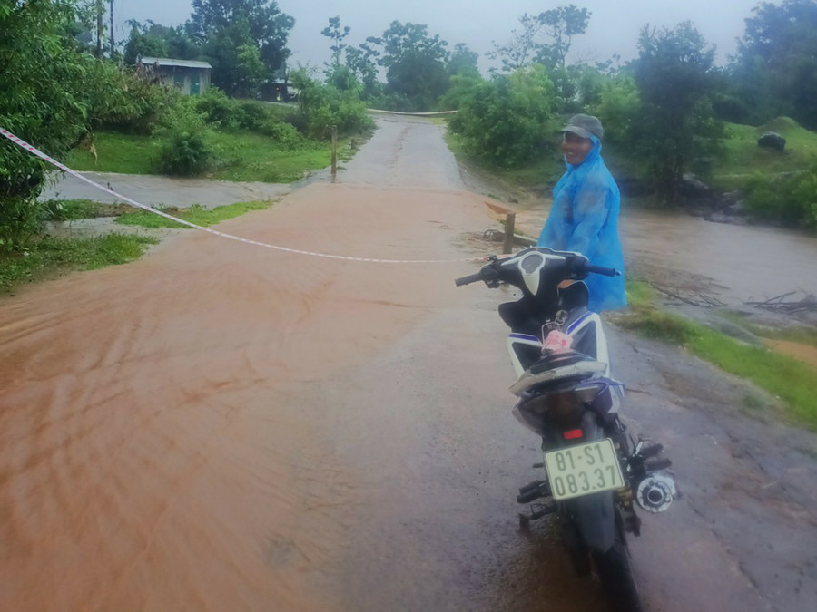 Lực lượng chức năng xã Kon Chiêng (huyện Mang Yang) túc trực tại điểm ngập lụt qua đập tràn trên tuyến đường dân sinh. Ảnh: H.V