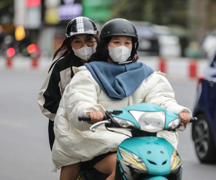 Người dân Hà Nội thêm áo rét khi di chuyển trên đường. (Ảnh: Thanh Tùng/TTXVN)