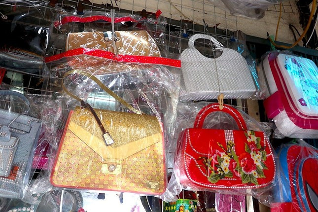 Nhiều mặt hàng được làm theo mẫu của các nhãn hiệu Gucci, Louis Vuitton,... treo đầy trên kệ hàng
