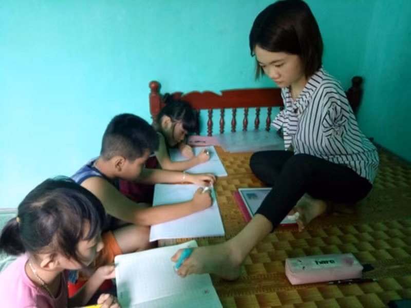 Đã 3 năm nay, cứ vào dịp hè, em Lê Thị Thắm lại mở lớp dạy tiếng Anh miễn phí cho những đứa trẻ nghèo trong xóm. Ảnh: Quách Du