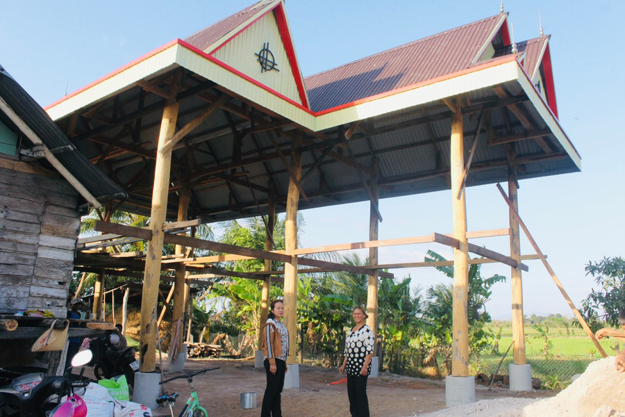 Là điển hình làm kinh tế giỏi của địa phương, bà Rô H&apos;Mrẽ (bìa phải) đang dựng căn nhà sàn mới ước tổng kinh phí khoảng 600 triệu đồng. Ảnh: Vũ Chi