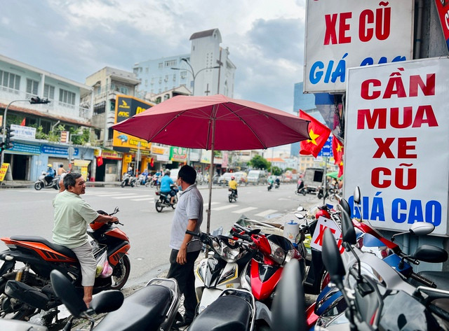 Biển số định danh: Chủ cũ xe đã chết thì sang tên chính chủ thế nào? - Ảnh 1. Người mua xe cũ quay lại hỏi chủ cửa hàng bán xe cũ về cách làm thủ tục sang tên chính chủ. Ảnh: Vũ Phượng