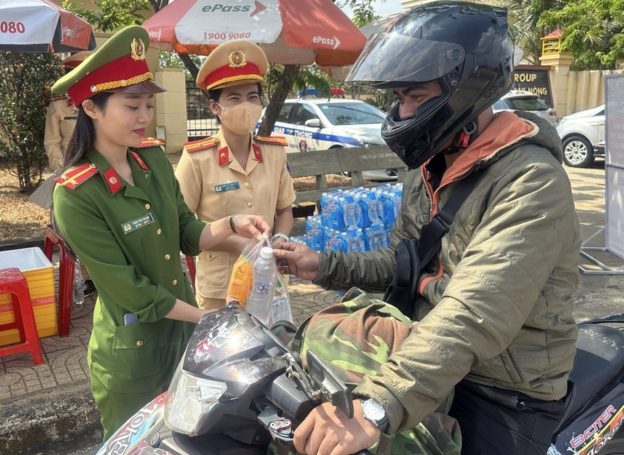 Công an hỗ trợ người dân di chuyển trên xe gắn máy để về quê đón Tết. (Ảnh: TTXVN phát)