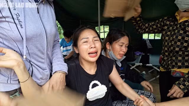 Chị Phương Linh khóc ngất khi có 2 con và mẹ chồng bị chết do lũ cuốn. Ảnh: Văn Duẩn