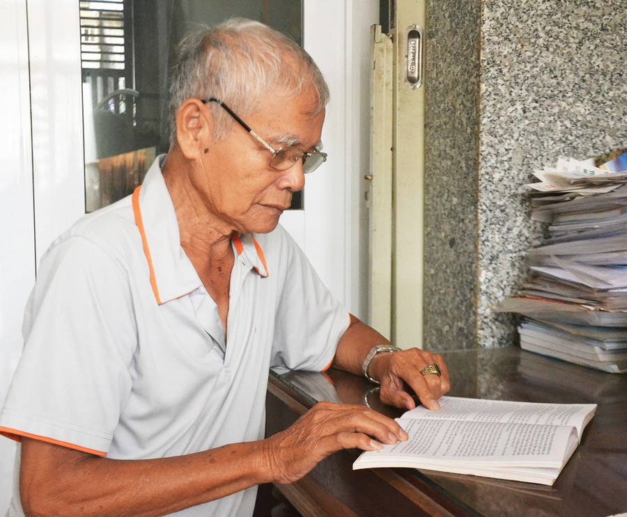 Ông Trần Chín-Phó Chủ tịch Hội Cựu TCT yêu nước tỉnh đọc sách tại nhà riêng. Ảnh: Hoàng Cư