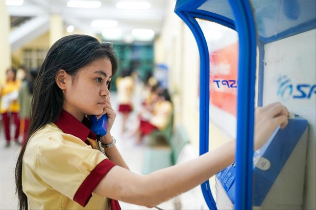 Không dùng điện thoại, học sinh Trường THPT Thành Nhân dùng điện thoại công cộng trong trường để gọi cho gia đình. Ảnh: Phạm Nguyễn Không dùng điện thoại, học sinh Trường THPT Thành Nhân dùng điện thoại công cộng trong trường để gọi cho gia đình. Ảnh: Phạm Nguyễn