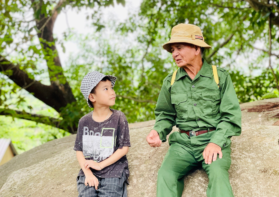 Ông Rơ Mah Djói say sưa kể những câu chuyện lịch sử về xã Gào anh hùng cho thiếu nhi. Ảnh: Mai Ka