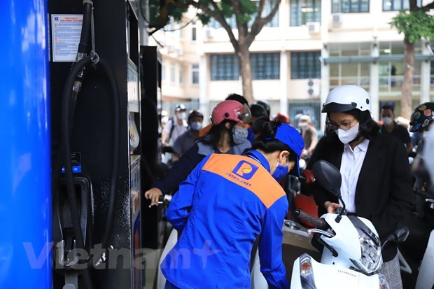 Nhân viên Petrolimex bán xăng cho khách hàng. (Ảnh: PV/Vietnam+)
