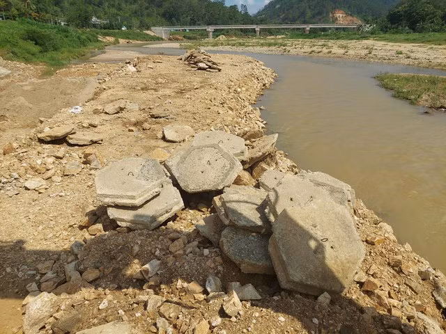 Gạch ốp mái bờ kè bị vứt lăn lóc ngoài bờ sông. Ảnh: ĐỨC NHẬT