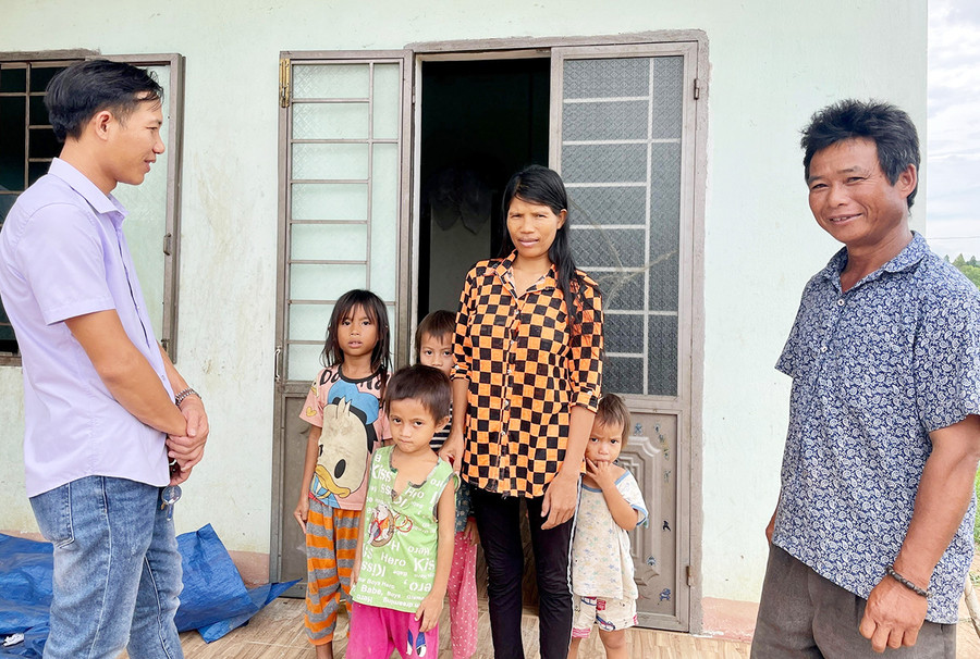 Ông Đinh Seng-Trưởng thôn Kuk Kôn (bìa phải) cùng cán bộ văn hóa xã đến thăm hỏi một gia đình từng theo tà đạo &quot;Hà Mòn”. Ảnh: Lam Nguyên