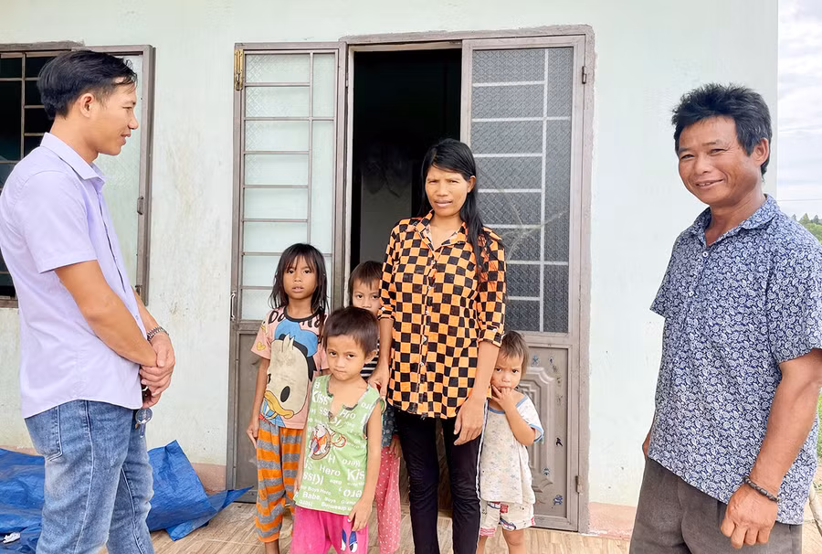 Ông Đinh Seng-Trưởng thôn Kuk Kôn (bìa phải) cùng cán bộ văn hóa xã đến thăm hỏi một gia đình từng theo tà đạo "Hà Mòn”. Ảnh: Lam Nguyên