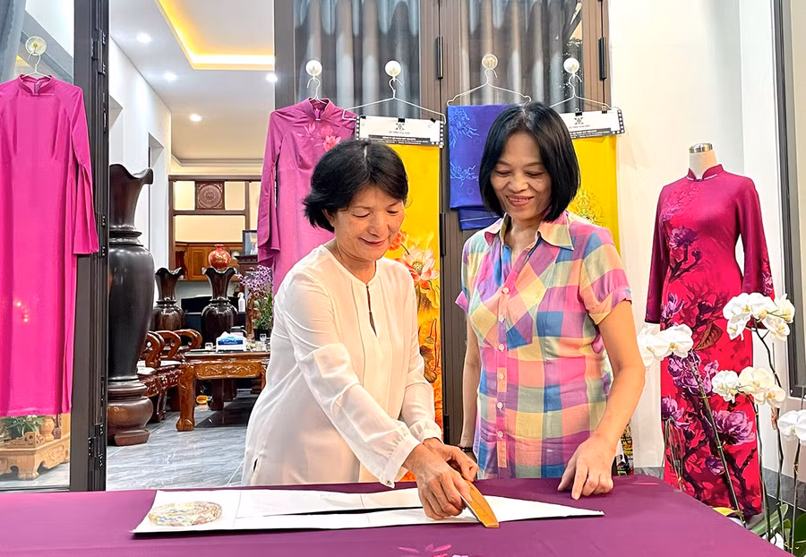 Bà Nguyễn Thị Hạnh (bìa trái) và bà Trần Thị Dung thực hành cắt may áo dài theo phương pháp ly vuông. Ảnh: L.N
