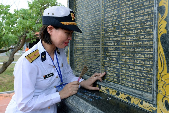 Thiếu tá Lê Thị Minh Thủy tới thăm khu tưởng niệm các chiến sĩ Gạc Ma và không thể rời tay khỏi tên cha mình được ghi ở khu mộ gió. Ảnh: Minh Thể