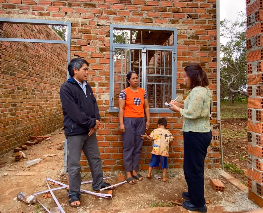 Chị Kpuih Vị (thứ 2 từ trái sang; trú tại làng Lang, xã Ia Dơk, huyện Đức Cơ) đứng bên ngôi nhà đang xây dở của mình. Ảnh: Hà Duy
