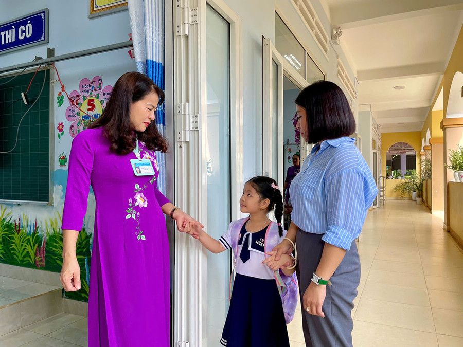 Cô giáo ân cần đón trẻ vào lớp 1. Ảnh: Bích Ngọc