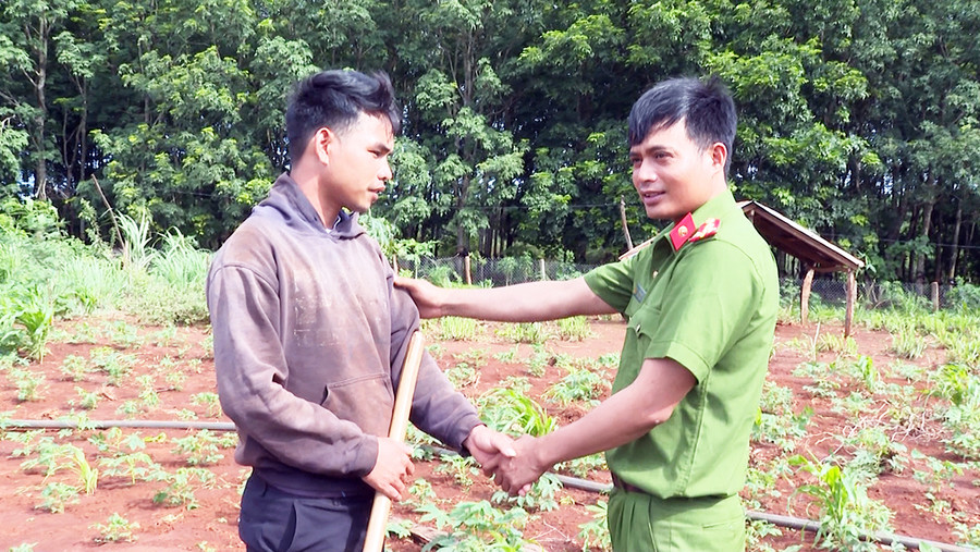 Cán bộ Công an xã Ia Hla (huyện Chư Pưh) thăm, động viên anh Rơ Mah To-1 trong 4 người DTTS bị lừa phỉnh vượt biên vừa trở về địa phương. Ảnh: Lê Ánh