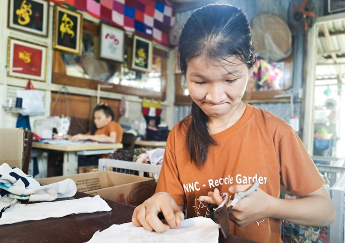 Một thành viên NNC tỉ mẩn tái chế vải vụn để tạo ra sản phẩm độc đáo