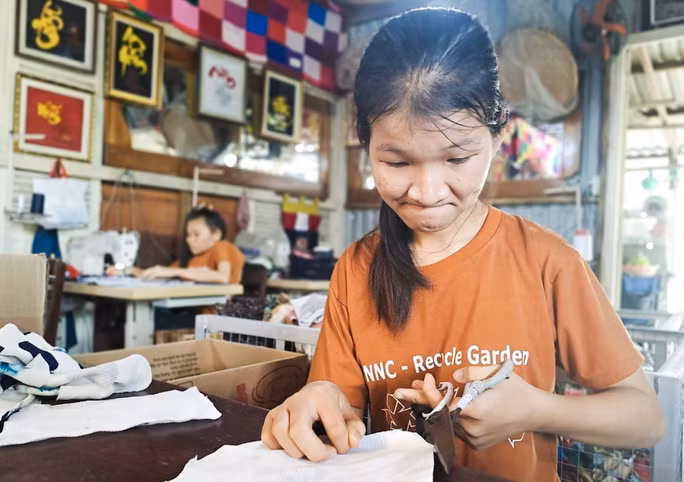 Một thành viên NNC tỉ mẩn tái chế vải vụn để tạo ra sản phẩm độc đáo