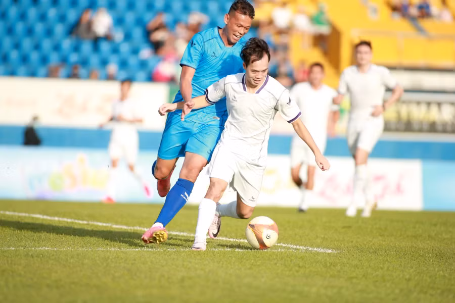 Tấn Trường tranh bóng cùng Văn Toàn. Ảnh Khang Nguyên