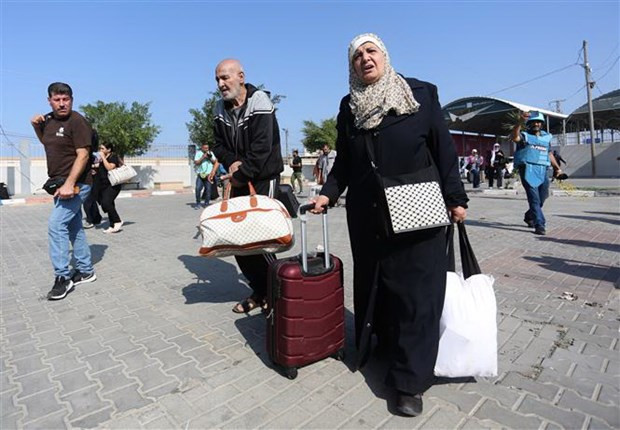 Người dân chuẩn bị rời khỏi Gaza qua Cửa khẩu Rafah. (Ảnh: THX/TTXVN)