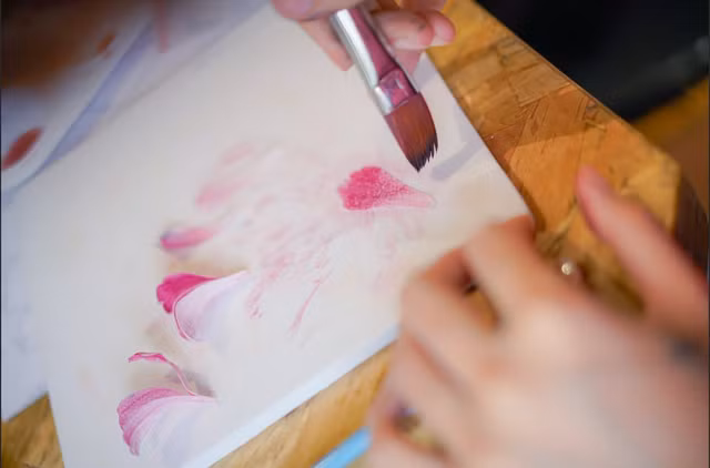 Anh Tín sẽ cắt và tô màu cho từng cánh hoa giấy gạo trước khi ghép. Ảnh: THƯỢNG HẢI