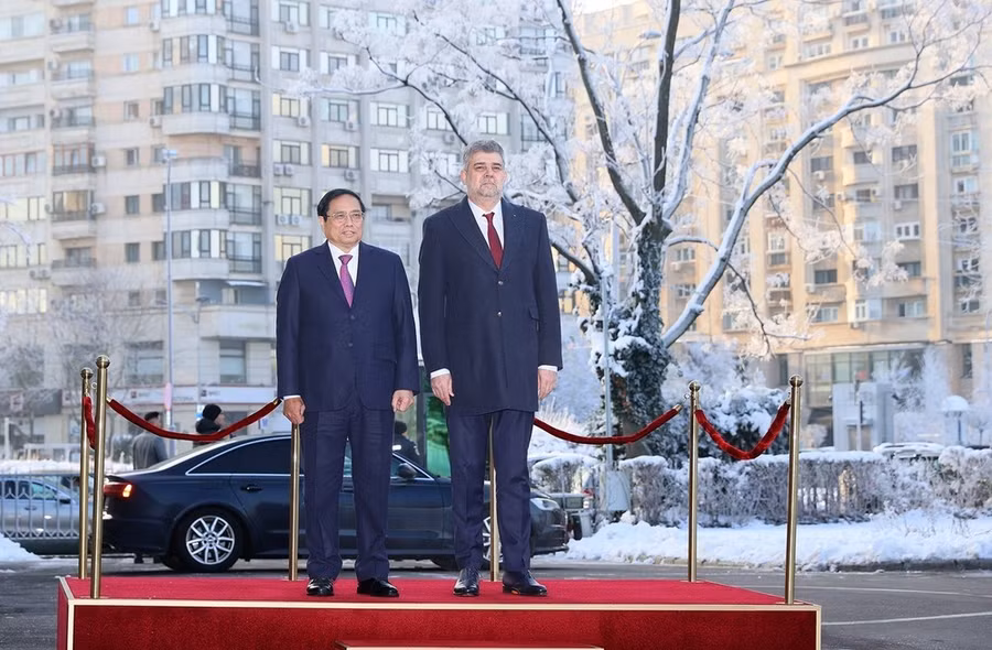 Thủ tướng Phạm Minh Chính và Thủ tướng Romania Ion-Marcel Ciolacu nghe quân nhạc cử Quốc thiều hai nước. (Ảnh: Dương Giang/TTXVN)