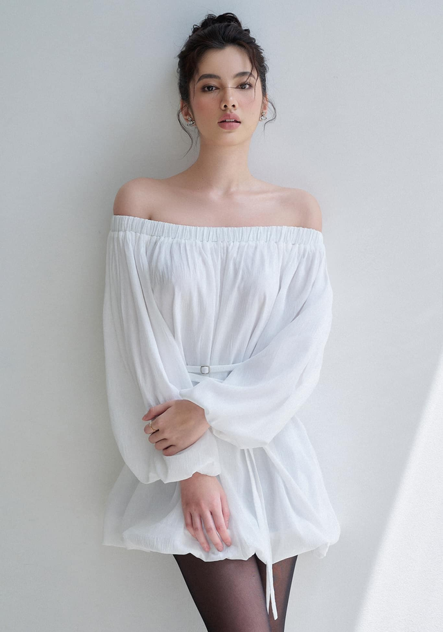Không quá cầu kỳ với trang phục dựng khối 3D hay drapping, một chiếc đầm ngắn trễ vai tay phồng mặc kèm thắt lưng bản nhỏ và tất da màu đen cũng đủ để nàng gây ấn tượng với người đối diện. Có thể thấy rằng thời trang màu trắng quá sức đa dạng, dễ biến hóa và thay đổi cho phù hợp với từng cô gái