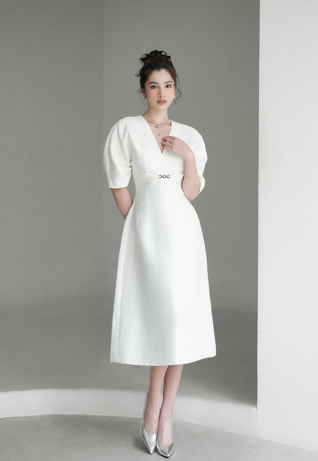 Không chỉ mang đến vẻ ngoài trung tính, thanh lịch và mới mẻ, váy dài tay phồng màu trắng với điểm nhấn tôn vòng 2, dáng cổ chữ V và tùng váy chữ A mang đến sự thoải mái cho nàng dù làm việc cả ngày