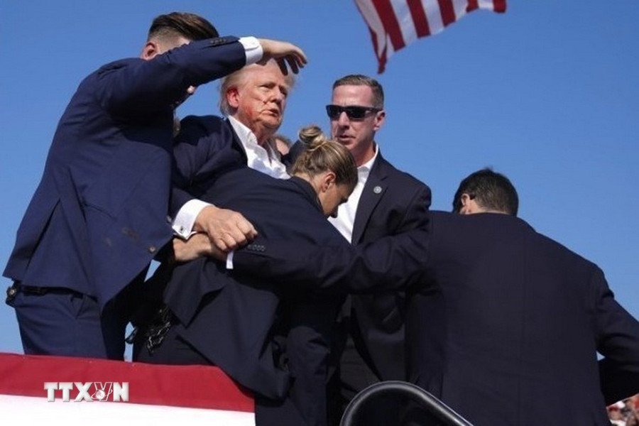 Cựu Tổng thống Donald Trump được mật vụ Mỹ hộ tống rời khỏi bục diễn thuyết trong cuộc vận động tranh cử ở thành phố Butler, bang Pennsylvania sau khi xảy ra vụ nổ súng, ngày 13/7. (Ảnh: THX/TTXVN') Cựu Tổng thống Donald Trump được mật vụ Mỹ hộ tống rời khỏi bục diễn thuyết trong cuộc vận động tranh cử ở thành phố Butler, bang Pennsylvania sau khi xảy ra vụ nổ súng, ngày 13/7. (Ảnh: THX/TTXVN')
