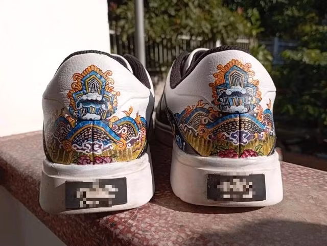 Hoàng Anh dùng màu acrylics vẽ họa tiết lên giày. ẢNH NVCC Hoàng Anh dùng màu acrylics vẽ họa tiết lên giày. ẢNH NVCC
