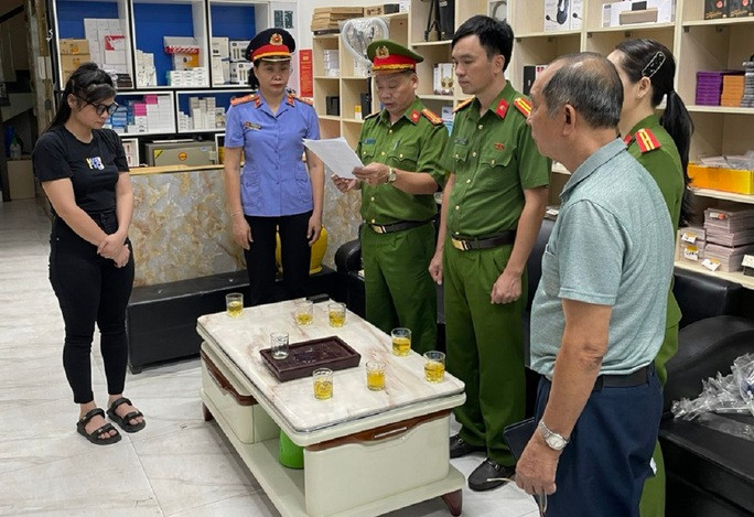 Phá đường dây buôn lậu hàng chục tỉ đồng linh kiện điện thoại từ Trung Quốc - Ảnh 1. Cơ quan công an đọc quyết định khám xét tại cơ sở kinh doanh của Hoàng Văn Cường. Ảnh: Công an Thanh Hóa
